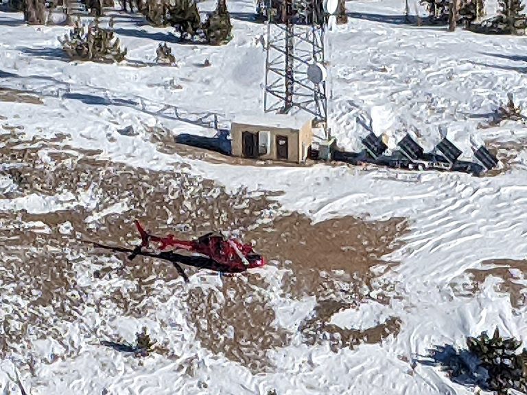 Helicopter at a snowed-in mountain-top repeater station